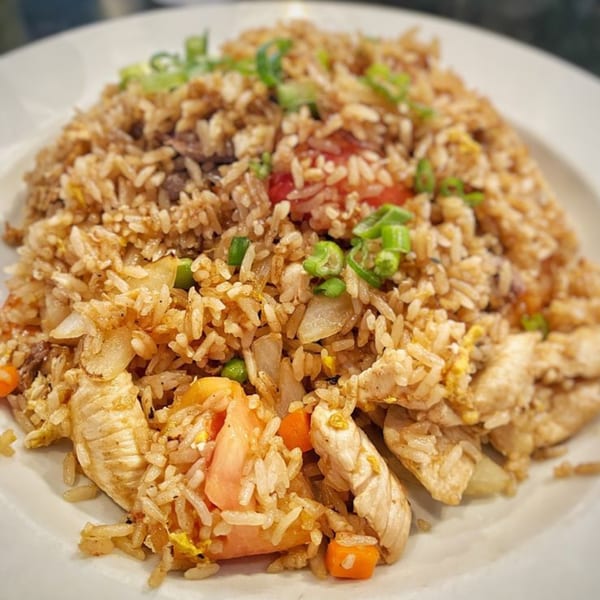 A close-up of Bonsai Thai & Sushi's chicken fried rice with vegetables and green onions.